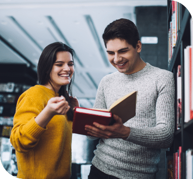 Two people reading books in a library.