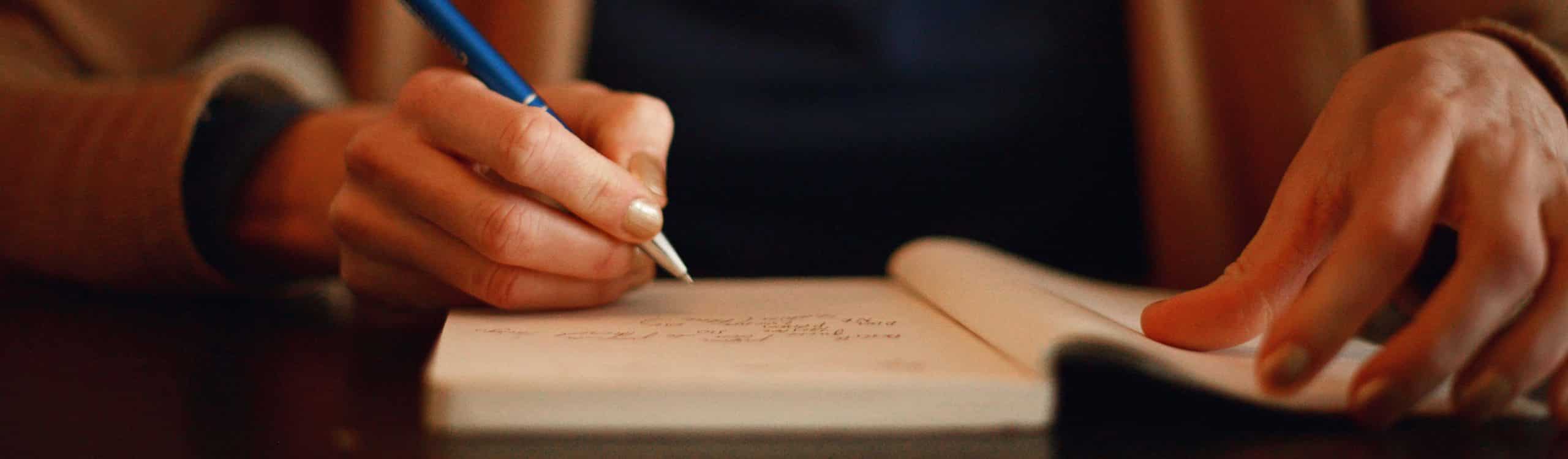 a woman writing in a notebook