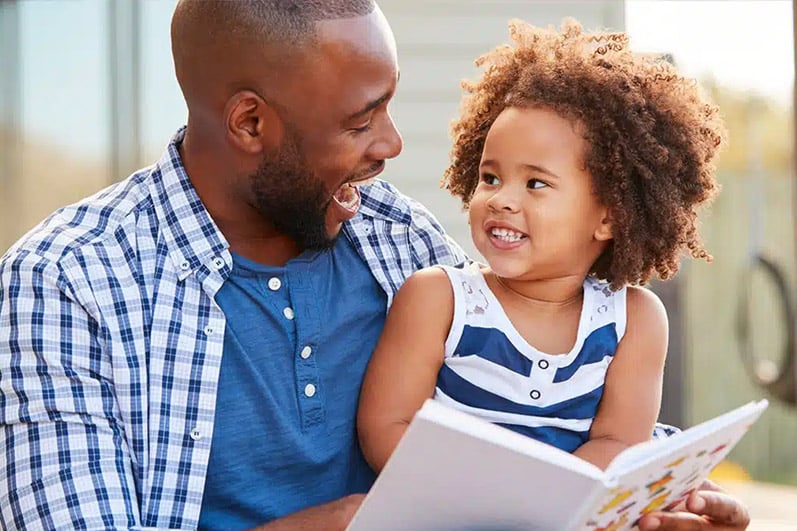 African American male reading a book to a child